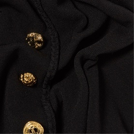 Claude Pierlot black womenswear fabric close-up showing three ornate gold lion-head buttons on a ribbed knit placket.