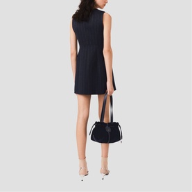 Model wearing Maje Womens French Dress in navy pinstripe, styled with a dark structured bag and nude heeled mules