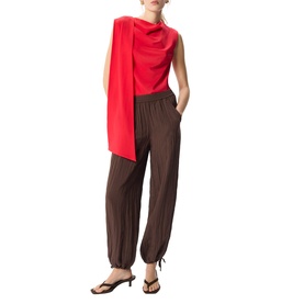 Model wearing Whistles brown elasticated-waist tapered trousers with gathered ankles, styled with a red draped top and black flat sandals.