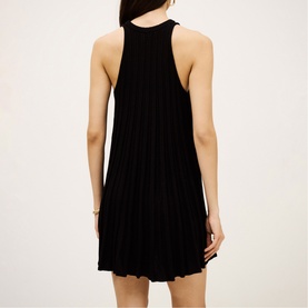 Model wearing Bash black sleeveless pleated mini dress, shown from the back with racerback neckline detail.