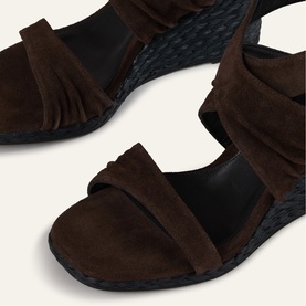 Bash brown suede wedge sandals with fringe detail, woven dark wedge sole and wide toe strap, close-up view