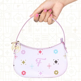FAO Schwarz multi-coloured mini shoulder bag with floral and star print, pink top handle, and gold logo charm