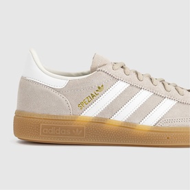Adidas Handball Spezial trainers in khaki and off-white suede with white three stripes, gold branding, and gum rubber sole.