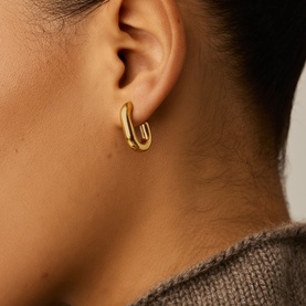 Model with Missoma gold double hoop earrings, chunky curved design, worn with a grey knit top