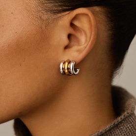 Model with Missoma gold and silver mixed-metal triple hoop earrings, worn on ear, chunky ridged design