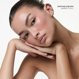 Model wearing Poco Beauty Universal Cream Stick in Bare It All, showing a natural flush on cheeks and lips with a dewy, minimal makeup look.
