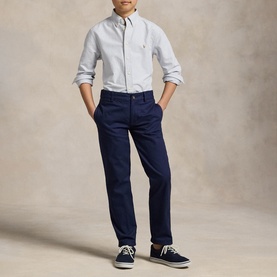 Model wearing Ralph Lauren striped shirt in light blue stripe with navy chinos and navy boat shoes.