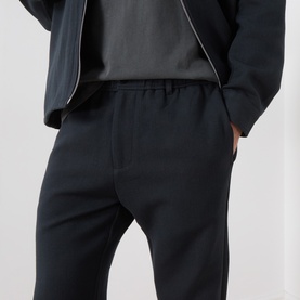 Model wearing Samsoe & Samsoe Jabari Casual Trousers in Dark Grey Mel, mid-rise straight-leg with elasticated waist, styled with dark jacket