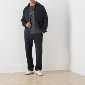 Model wearing Samsoe & Samsoe Jabari Casual Trousers in Dark Grey Mel, straight-leg fit with elasticated waist, styled with dark zip jacket and white