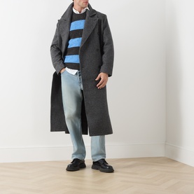 Model wearing Samsoe & Samsoe Dark Grey Mel wool coat, styled with blue striped knit, white shirt, light blue jeans and black loafers.