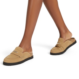 Model wearing Steve Madden brown suede mule loafers with gold-tone hardware and black lug sole