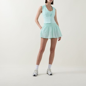 Model wearing Tala SkinLuxe Contrast Piping Sports Bra in Soft Mint with matching shorts, white socks and grey trainers.