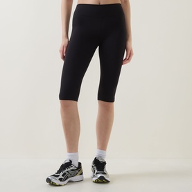 Model wearing Tala Shadow Black cropped leggings, styled with white ankle socks and multi-coloured trainers.