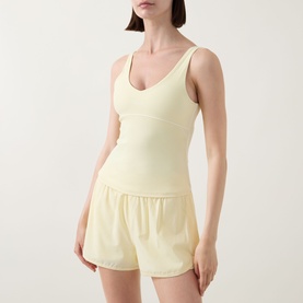 Model wearing Tala SkinLuxe Contrast Piping Tank Top in Lemon Yellow with matching shorts. V-neckline, fitted stretch fabric.