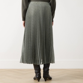 Model wearing Vince light green pleated midi skirt, styled with dark knit top and black knee-high boots