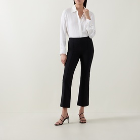 Model wearing Vince black cropped flare trousers, styled with a white shirt and black strappy heeled sandals.