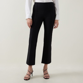 Model wearing Vince black cropped flare trousers, styled with a white shirt and black strappy heeled sandals.