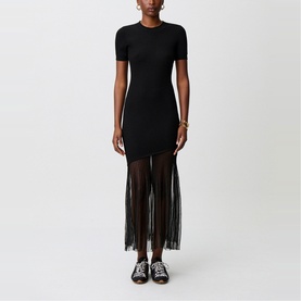 Model wearing Claude Pierlot black short-sleeve fitted midi dress with sheer fringed skirt, styled with black flat sandals.