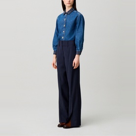 Model wearing Claude Pierlot Straight Leg Trousers in blue with thick waistband and front seam detail, styled with a denim shirt.