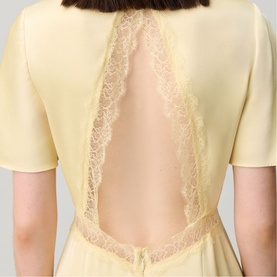Model wearing Claude Pierlot Lace Slit Dress in baby yellow, showing open back detail with lace trim insert and short sleeves.
