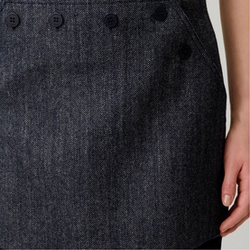 Model wearing Claude Pierlot black woven dress, close-up detail of decorative button placket at hip