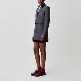 Model wearing Claude Pierlot black French dress with matching cropped double-breasted tweed blazer, styled with red socks and dark loafers