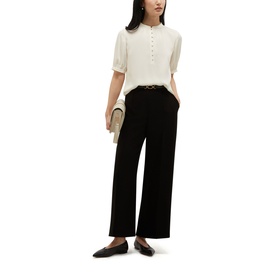 Model wearing Hobbs cream short-sleeve button-neck top with wide-leg black trousers and black loafers, carrying a small clutch