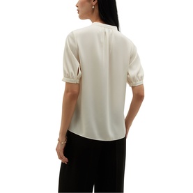 Model wearing Hobbs cream short puff-sleeve blouse with lace trim cuffs, styled with black wide-leg trousers, rear view