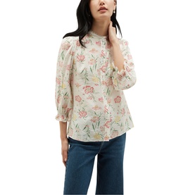 Model wearing Hobbs ivory multi floral blouse with high neck, sheer puff sleeves, and ruffle cuffs, styled with blue jeans