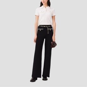 Model wearing Maje Womens French Dress in red, styled with black wide-leg trousers, white polo top, and black belt with gold hardware.