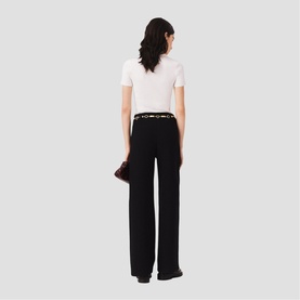 Model wearing Maje Womens French Dress in red, shown from behind, styled with black wide-leg trousers and white fitted top.