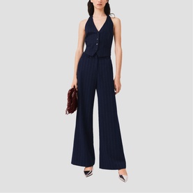 Model wearing Maje navy pinstripe wide-leg trousers and matching halterneck waistcoat, styled with burgundy bag and silver heels
