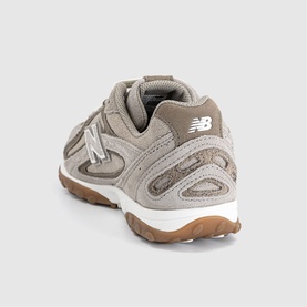 New Balance trainer in Dark Olivine Gum, rear three-quarter view showing suede upper, white midsole and gum rubber outsole.