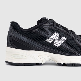 New Balance trainer in black with sea salt leopard print N logo, chunky off-white sole, mesh and synthetic upper detailing.