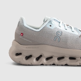 On Running trainer in Cinder Iceberg, featuring textured mesh upper, Swiss flag detail, and chunky cloud sole unit, angled side view.