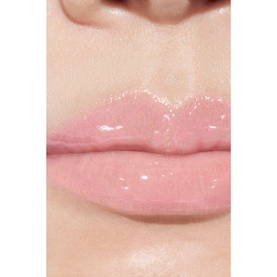 Model wearing Chanel Lip Gloss in shade 432 Cristal, a sheer glossy pink on lips