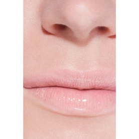 Chanel lip gloss shade 432 Cristal worn on lips, showing sheer glossy pink finish on close-up model shot