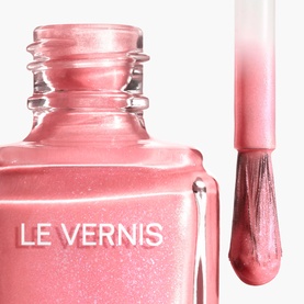 Chanel Le Vernis nail varnish in 421 Cristalline, sheer pink shimmer formula shown in open bottle with brush applicator