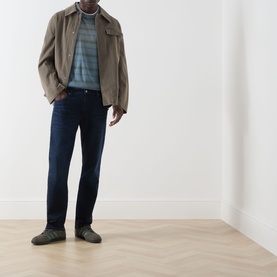Model wearing Citizens of Humanity blue straight jeans styled with a beige jacket, striped top, and grey trainers.