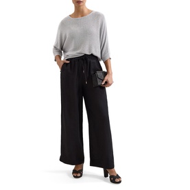 Model wearing black wide-leg trousers with tie waist, styled with grey knit top and black heeled mules, carrying small black clutch