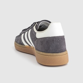 Adidas trainer in grey strata suede with white three-stripe detail, off-white heel tab and gum rubber sole, rear angle view.