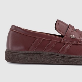 Adidas loafer trainer in fox brown leather with three-stripe detail, silver logo, and dark brown rubber sole.