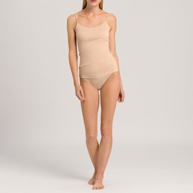 Model wearing Hanro beige brief with matching cami top, thin shoulder straps, smooth seamless finish, full front view
