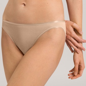 Model wearing Hanro beige brief with smooth fabric finish and slim waistband, styled for a minimal, seamless look.