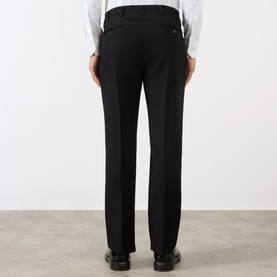 Model wearing Prada Gabardine Tailored Trousers in black, slim-leg with pressed creases and buttoned back welt pockets, styled with black leather