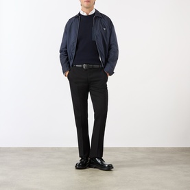 Model wearing Prada Gabardine Tailored Trousers in black slim-leg wool, styled with navy bomber jacket, navy knit and black loafers.