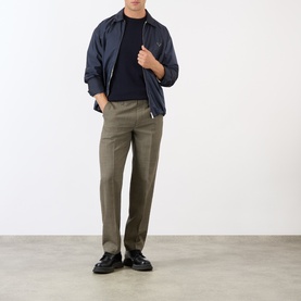 Model wearing Prada Houndstooth Check Trousers in Military, slim-leg wool, styled with navy jacket and black loafers