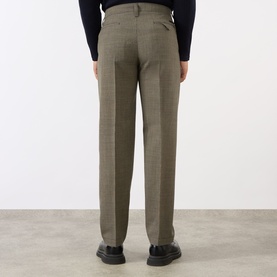 Model wearing Prada Houndstooth Check Trousers in Military, slim-leg wool, rear view styled with black turtleneck and black shoes.