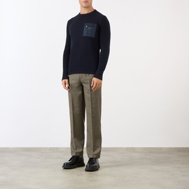 Model wearing Prada Houndstooth Check Trousers in Military wool, slim-leg fit, styled with navy knit sweater and black loafers.