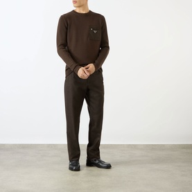 Model wearing Prada brown wool crew neck jumper with chest pocket, styled with matching brown trousers and black leather shoes.